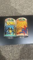 Photo showing both vintage Chef Boyardee X-Men Wolverine and Spider-Man coin banks side by side.