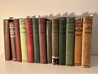 Front view of 12 cloth-bound hardcover Dave Dawson books showing varied spine colors and titles.