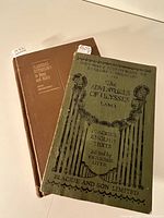 Two mythology books side by side on a white surface showing the front covers and spines. The brown hardcover book shows the title 'Classical Mythology in Story and Art,' the green softcover book shows the title 'The Adventures of Ulysses' with vintage decorative artwork.