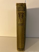 Spine of The Lone Star Ranger book showing title, author, and publisher Grosset & Dunlap, with some wear and fraying at edges.