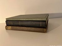 Stack of three hardcover books with titles Courage, A Guide to Civilized Leisure, and The Human Machine, viewed edge-on