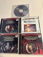 Photo showing 4 CD jewel cases and one loose CD, titles visible for Mozart Experience and Beethoven Classic Gold.