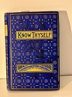 Front cover of the book titled 'Know Thyself' with blue and gold decorative design and gold gilded edges visible.