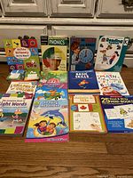 Photo displaying all 13 educational books and workbooks arranged on the floor, showing front covers and titles from various publishers.
