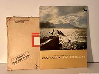 Photo of original album cover with ocean scene and birds, alongside original Maclean-Hunter Manila envelope labeled 'PRINTS DO NOT FOLD'