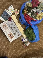 Overhead photo showing all items in the lot including books, Nativity sets boxes, floral decor, wood letters, wreath, and ornaments