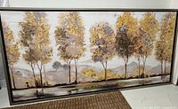 Full view of the original mixed media landscape painting showing autumn trees in gold and brown hues in a horizontal rectangular format with metal frame.
