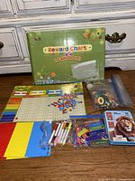 Photo of all kit contents including large magnetic reward chart, colorful magnetic stars, chore magnets, blank magnets, dry erase markers, and additional small magnetic items in a resealable bag.