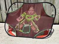 View of the hockey net side with fabric goalie target and shooting hole.