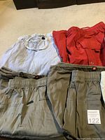 10 pairs of men's XL shorts in various colors laid out on carpet, visible elastic waistbands and different designs