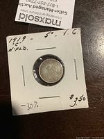 Obverse or reverse side of 1919 Newfoundland 5 cent coin labeled in holder showing condition and price.