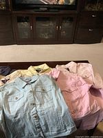 7 medium Azur jean jackets in various colors arranged on a table, front view highlighting button closures and chest pockets.