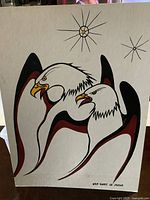 Front view of the Indigenous artwork showing the design of two eagles and the artist's signature.