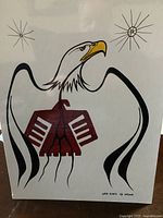 Full view of the framed Indigenous eagle artwork showing stylized wings, body and head with artist signature.