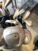 Golf club set showing irons 3 to 9 and multiple wedge clubs in a black golf bag.