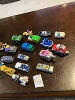 Photo of all 20 toy cars arranged on dark brown surface showing variety of makes and styles