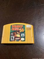 Front of yellow Nintendo 64 cartridge showing Donkey Kong 64 label, rating, and logo.