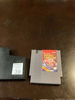 Photo of the original NES Double Dragon game cartridge next to a black plastic protective sleeve labeled with number 39.
