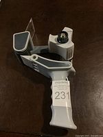 Packing tape dispenser showing handle, tape roller, and cutting edge