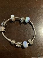 Full view of bracelet showing all charms arranged on a wooden surface
