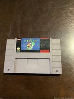 Front side of the Super Nintendo cartridge showing the Super Mario World label with Mario and Yoshi artwork.