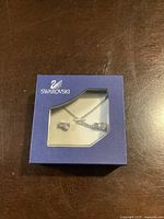 Blue Swarovski box showing necklace and earrings through transparent lid.