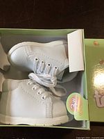 Photo of white Tenny Toes baby baptism shoes size 3 wide in original green box with floral decoration.