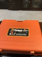 Closed orange plastic hard case labeled Paslode FSC200 2-in-1 Flooring Stapler & Cleat Nailer