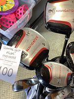 Close-up of Navigator brand golf club heads showing lofts and numbers including 19°, 5, and 18° pitching wedge wood.