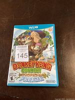 Front cover of the Wii U game case Donkey Kong Country Tropical Freeze with label sticker showing lot number 145.