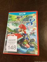 Front cover of the red Nintendo Wii U case for Mario Kart 8 showing the game's colorful artwork with Mario driving a kart.