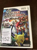 Front view of the Wii game case with vibrant cover art featuring characters like Mario and Pikachu for Super Smash Bros Brawl.