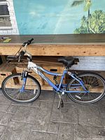 Side view of blue and white Avalon bicycle with aluminum frame and black saddle, showing overall condition and structure.