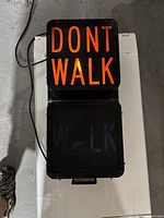 Top view of pedestrian crosswalk signal showing illuminated DONT WALK in orange and WALK sign off.