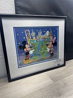 Framed artwork showing Mickey and Minnie Mouse with a Disneyland destination map, black frame, overall size 19x16 inches.