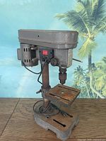 Full view of the five speed drill press showing motor housing, column, drill table, and base with electrical cord.