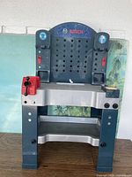Front view of the child's Bosch plastic toy workbench showing red vice and general structure.