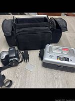 Kodak DX6490 camera, printer dock, black carrying case, power cable and charging cradle displayed on table