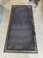 Top view of the large rectangular display case showing black wooden frame and glass top with dust.