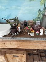 Full view of large miscellaneous kitchen and household lot with various items including Tupperware, salt shakers, candy dishes, baskets, and decorative ceramics.