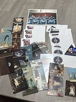 Full lot view showing space postcards, cover envelopes with ID cards, mission sticker, and Challenger crew photo on gray table.