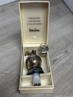 Original box with inner lid inscription, containing Neiman Marcus silver plated dove and globe bottle stopper and metal capped David Off Cognac stopper.
