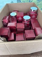 Photo of full open cardboard box filled with multiple red boxes and jars of Seriesse SuperMel C Essentials beauty cream.