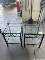 Pair of metal framed end tables with two glass shelves, showing full view from above.