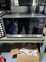 Front view of Panasonic microwave oven showing stainless steel exterior and black glass door.