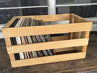 Wooden crate with vertical vinyl records inside, showing capacity and condition of crate and records