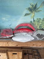 Multiple red and white plastic motorcycle accessory pieces on table, many still in original UFO packaging plastic.