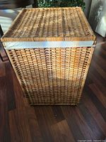 Front view of wicker laundry hamper showing overall shape and weave
