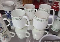 Group of four shamrock mugs with blue scenic mug behind