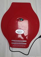 Closed red Betty Crocker electric pizza maker showing exterior and power indicator